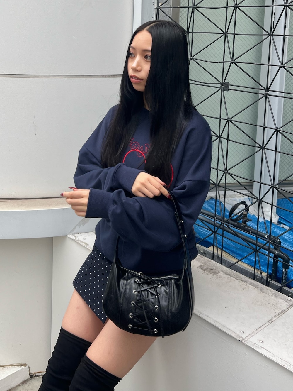 ブルー系のスウェット、ブルー系のスカート、ブラック系のブーツを着用したレディースの秋コーディネートの4枚目の写真