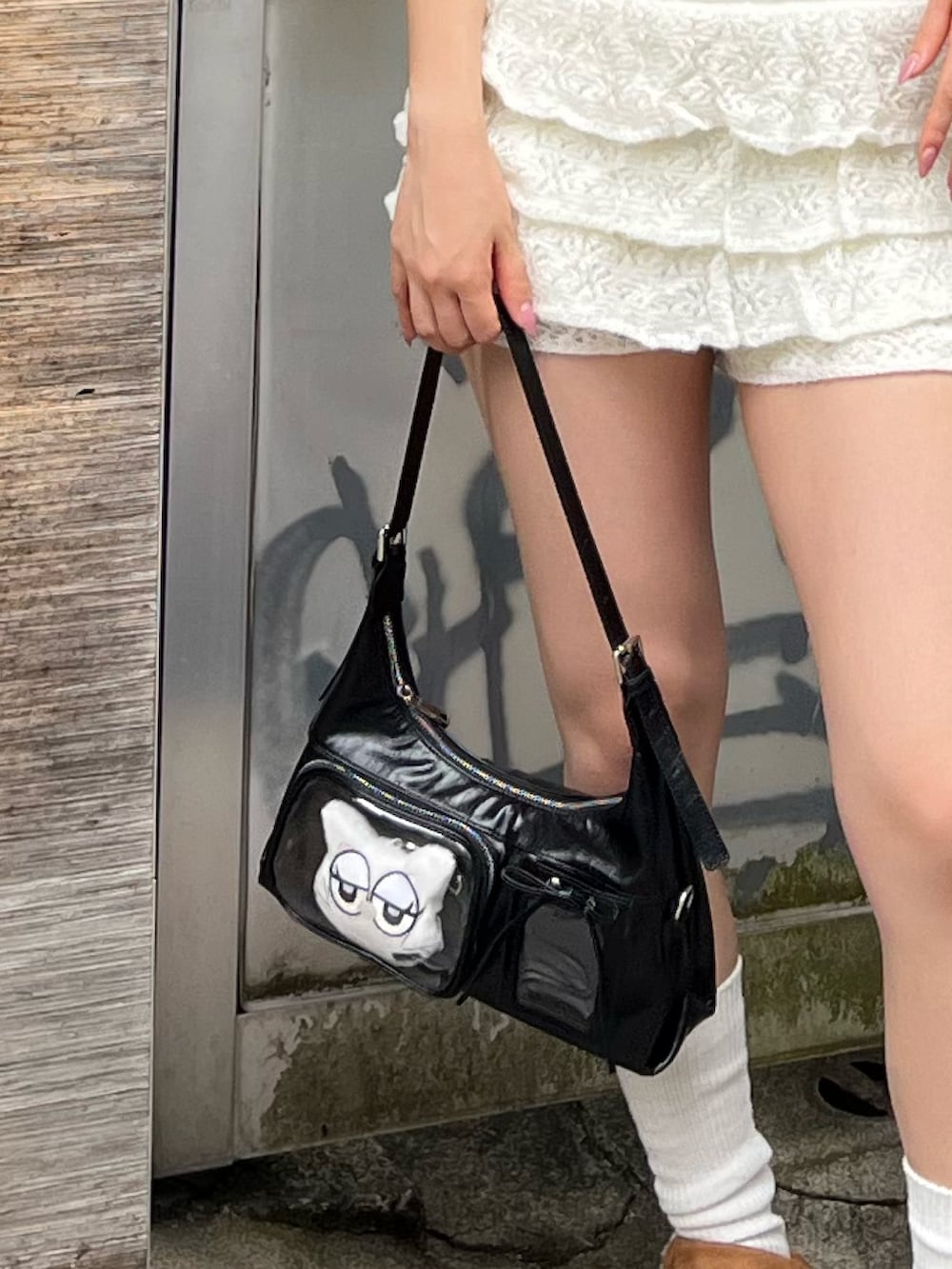 ホワイト系のTシャツ/カットソー、ホワイト系のスカート、ブラック系のハンドバッグを着用したレディースの秋コーディネートの5枚目の写真