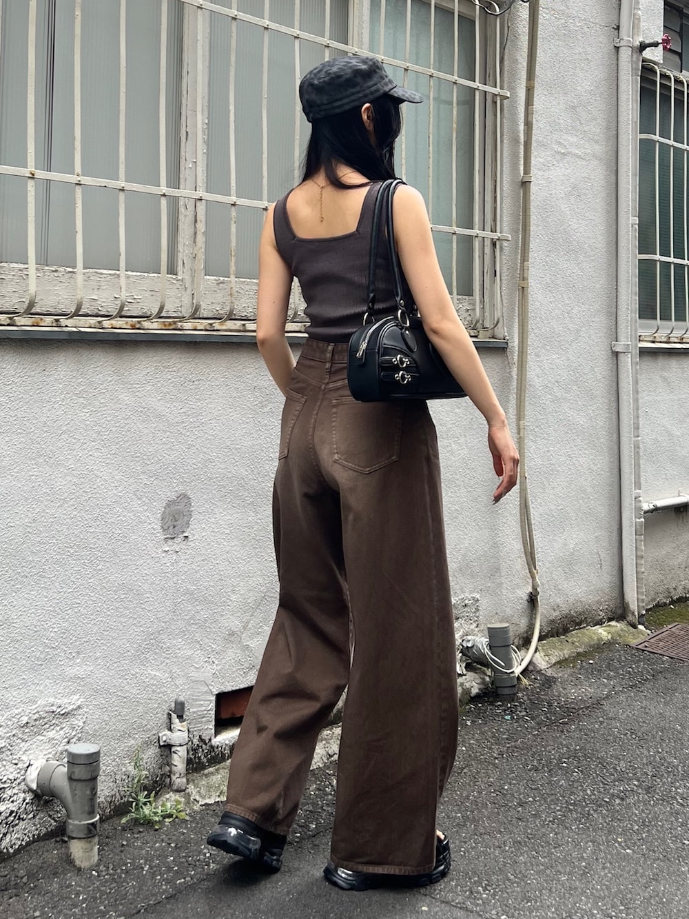 ブラウン系のデニムパンツ、ブラック系のサンダル、ブラック系のハンドバッグを着用したレディースの夏コーディネートの3枚目の写真