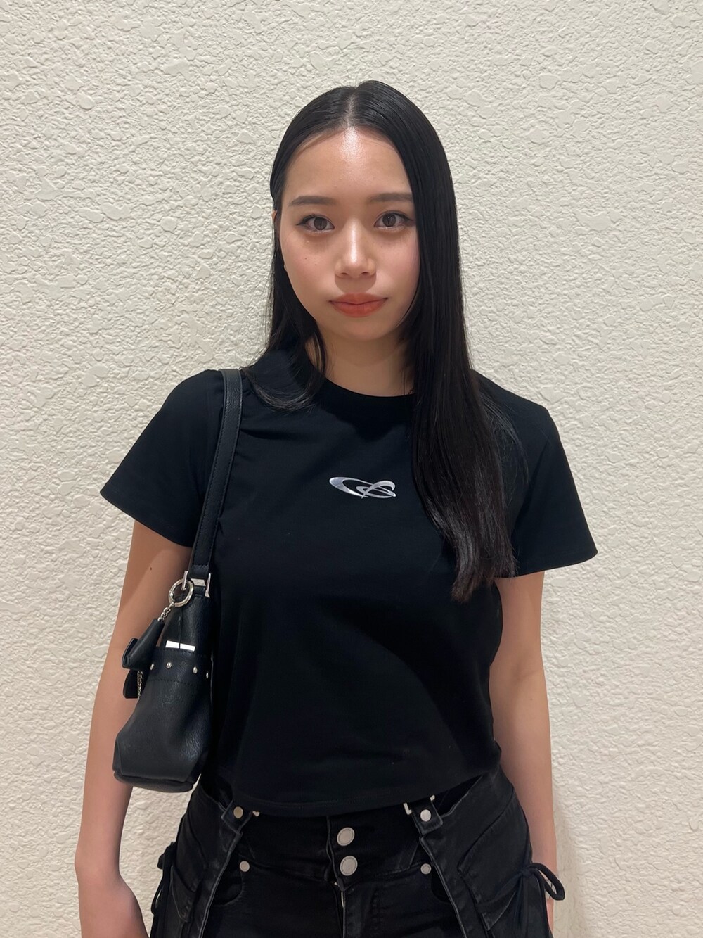 ブラック系のTシャツ/カットソー、ブラック系のハンドバッグ、ブラック系のデニムパンツを着用したレディースの春コーディネートの4枚目の写真