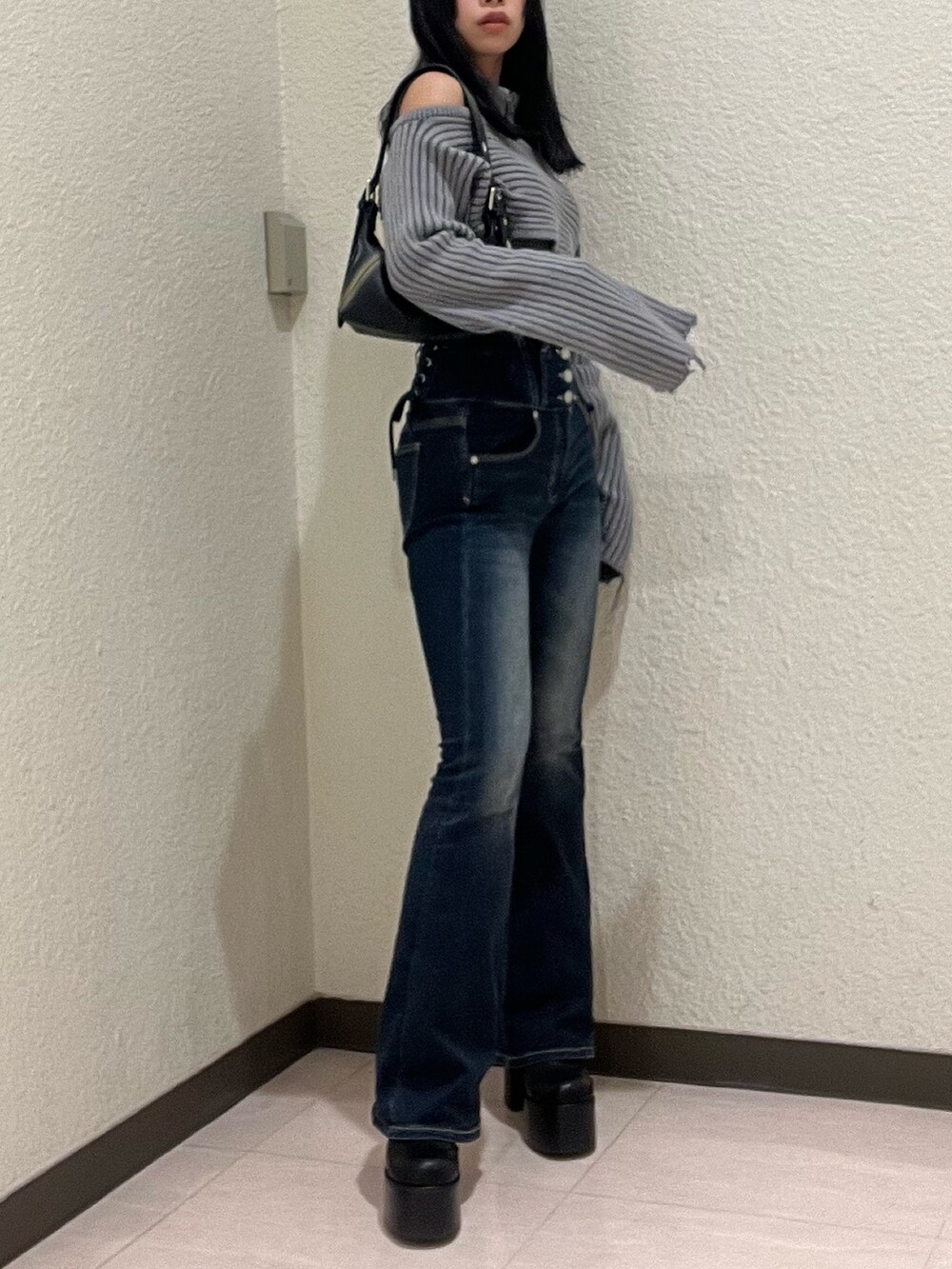 ブルー系のデニムパンツ、グレー系のニット/セーター、ブラック系のハンドバッグを着用したレディースの秋コーディネートの3枚目の写真