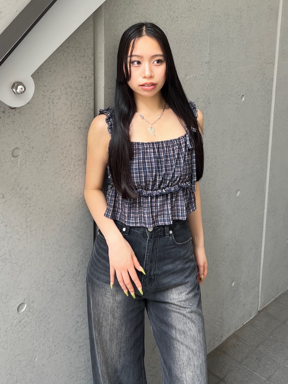 ブラウン系のタンクトップ、ブラック系のデニムパンツ、ブラック系のサンダルを着用したレディースの夏コーディネートの4枚目の写真