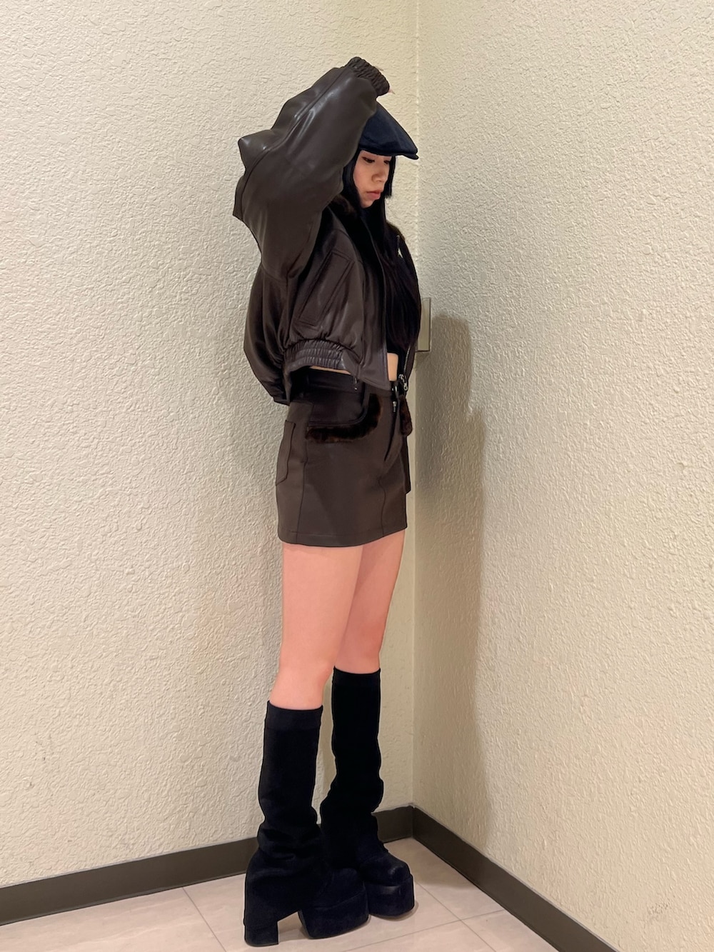 ブラウン系のブルゾン、ブラック系のニット/セーター、ブラウン系のスカートを着用したレディースの冬コーディネートの2枚目の写真