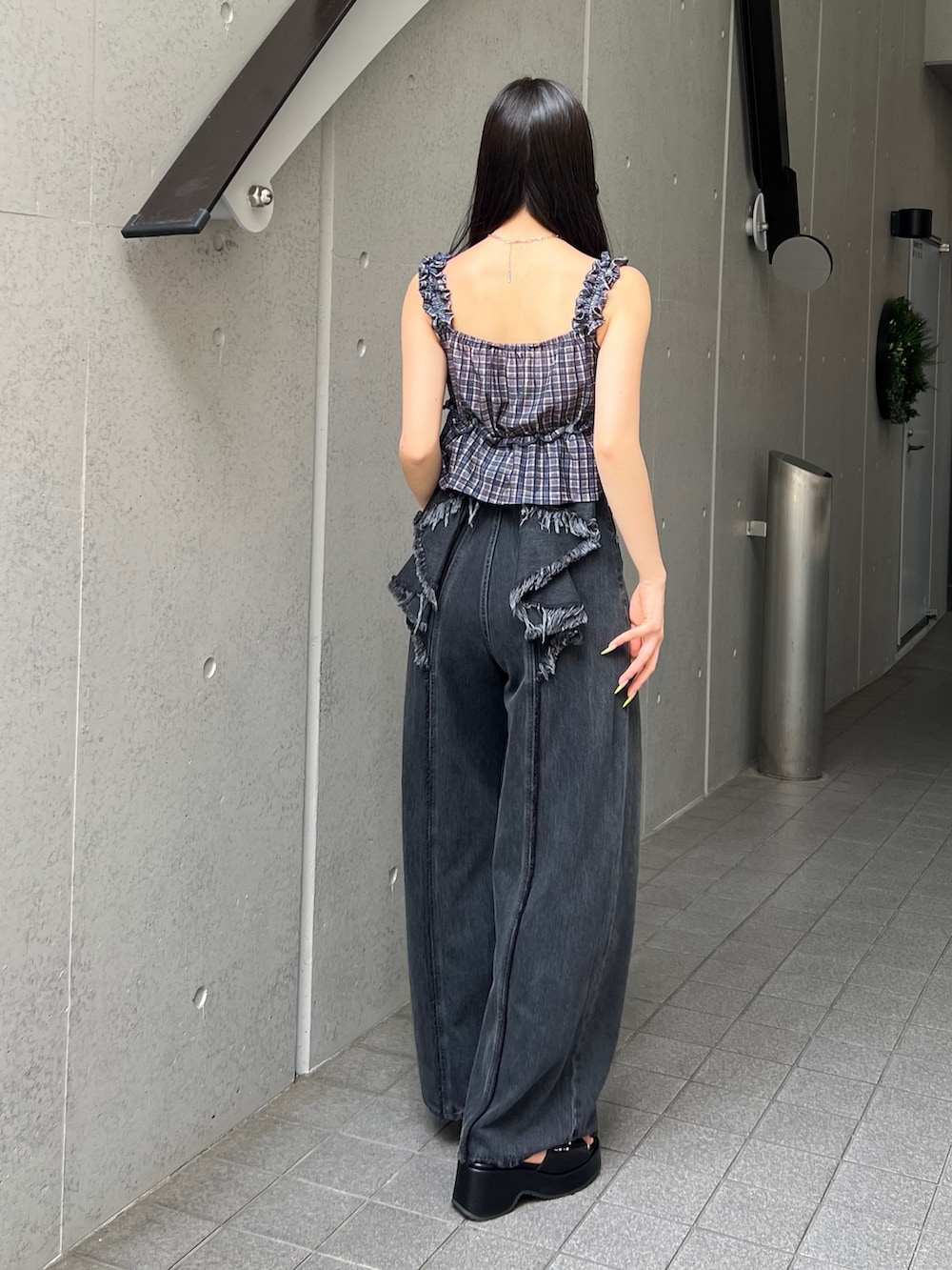 ブラウン系のタンクトップ、ブラック系のデニムパンツ、ブラック系のサンダルを着用したレディースの夏コーディネートの3枚目の写真