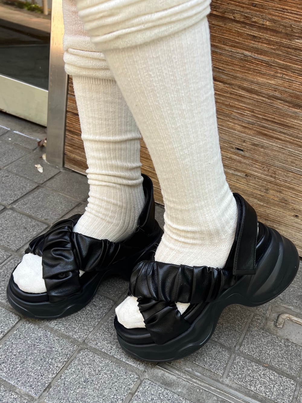グレー系のスカート、ブラック系のハンドバッグ、ブラック系のサンダルを着用したレディースの夏コーディネートの6枚目の写真