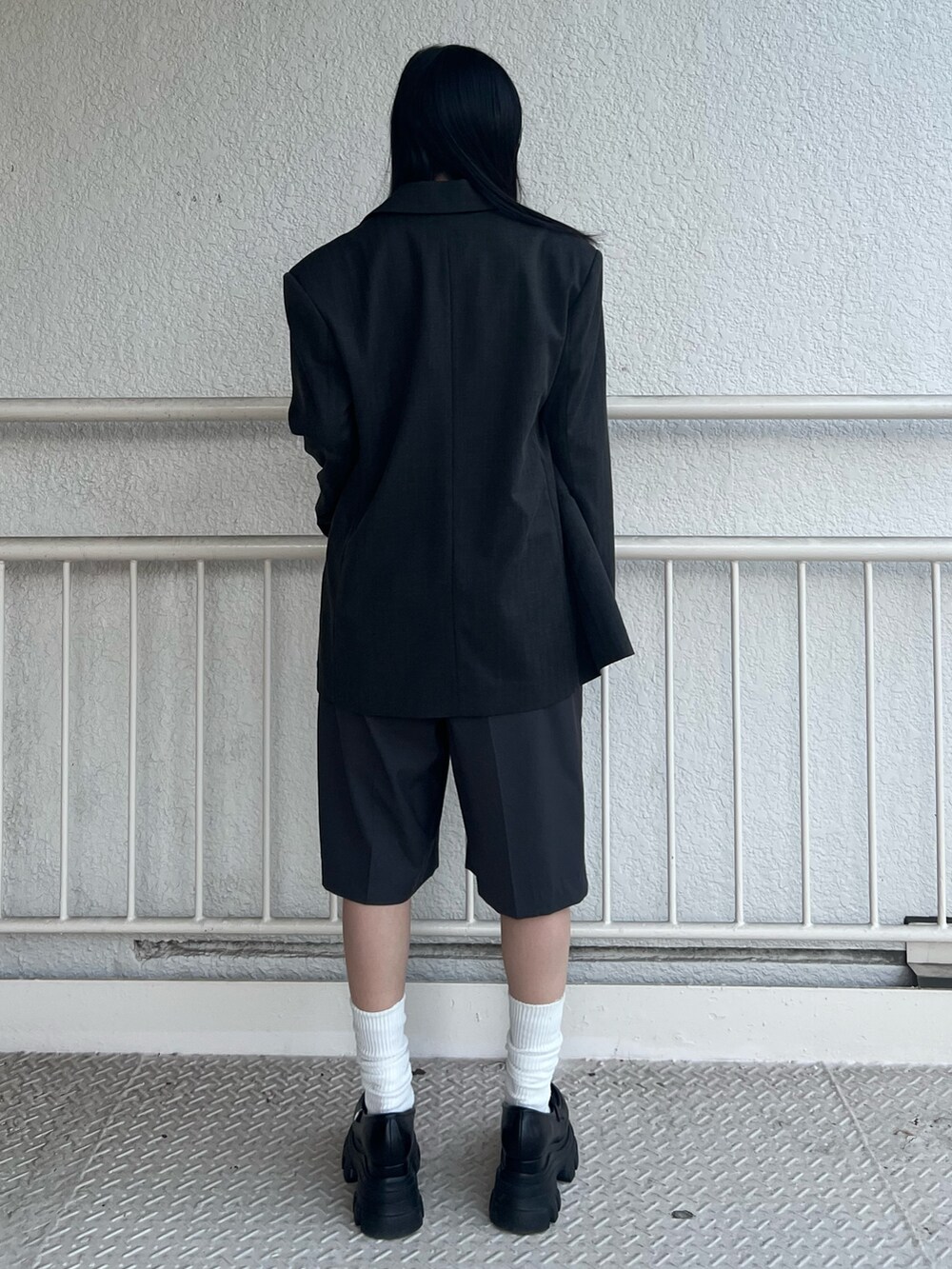 グレー系のテーラードジャケット、ブラック系のニット/セーター、グレー系のその他パンツを着用したレディースの春コーディネートの3枚目の写真