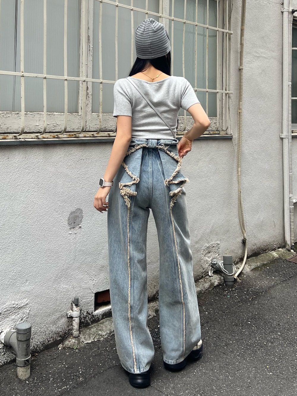 グレー系のニット/セーター、ブルー系のデニムパンツ、グレー系のニットキャップ/ビーニーを着用したレディースの春コーディネートの3枚目の写真