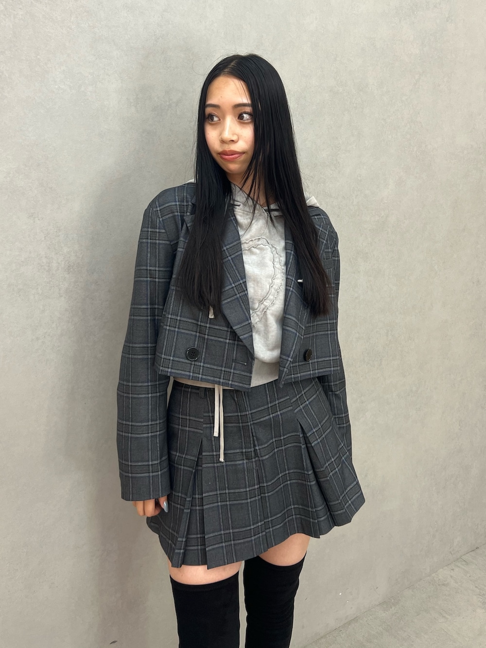 グレー系のテーラードジャケット、グレー系のスカート、グレー系のパーカーを着用したレディースの秋コーディネートの4枚目の写真