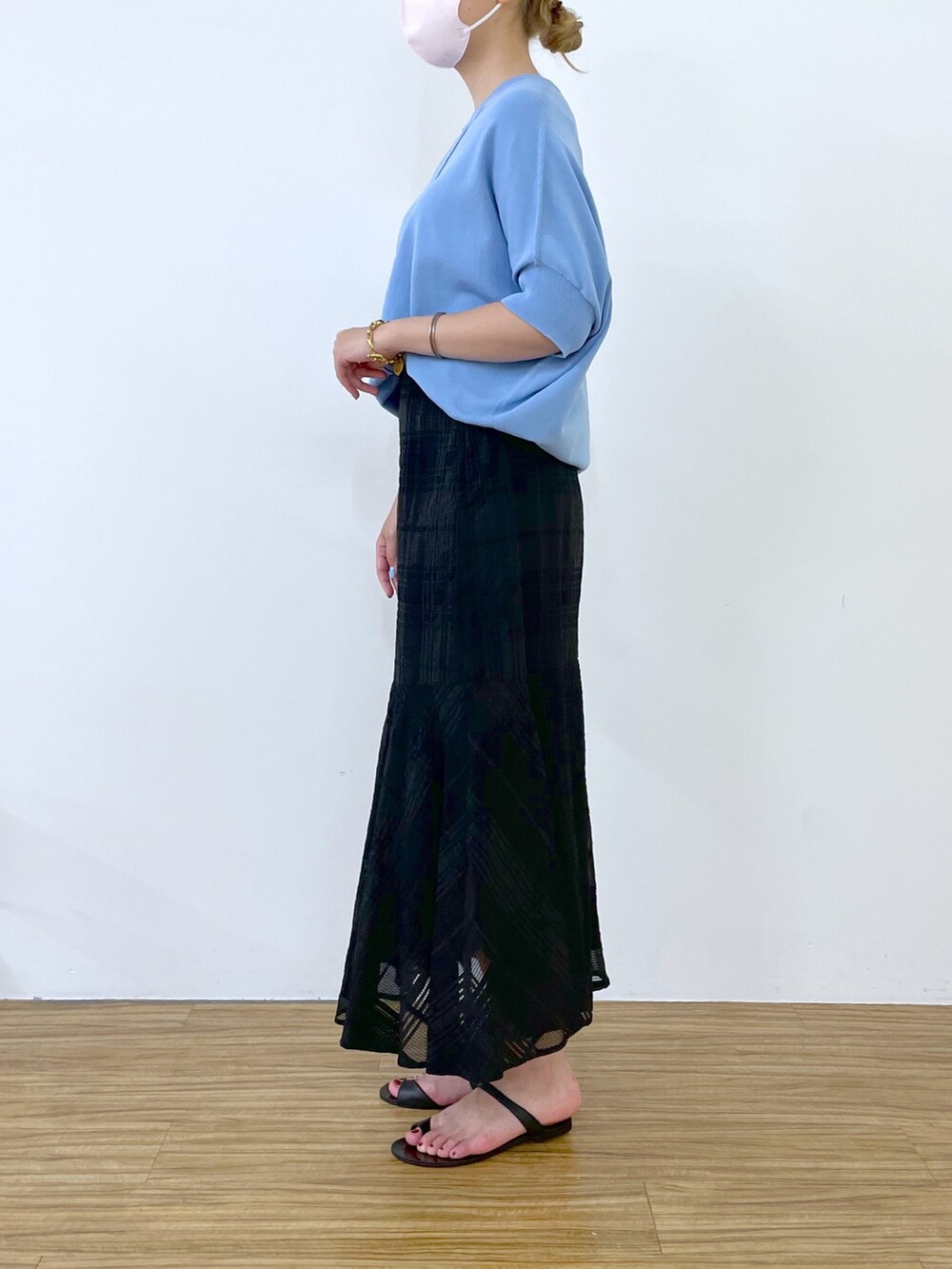 ブルー系のニット/セーター、ブラック系のスカート、ブラック系のその他シューズを着用したレディースの春コーディネートの2枚目の写真