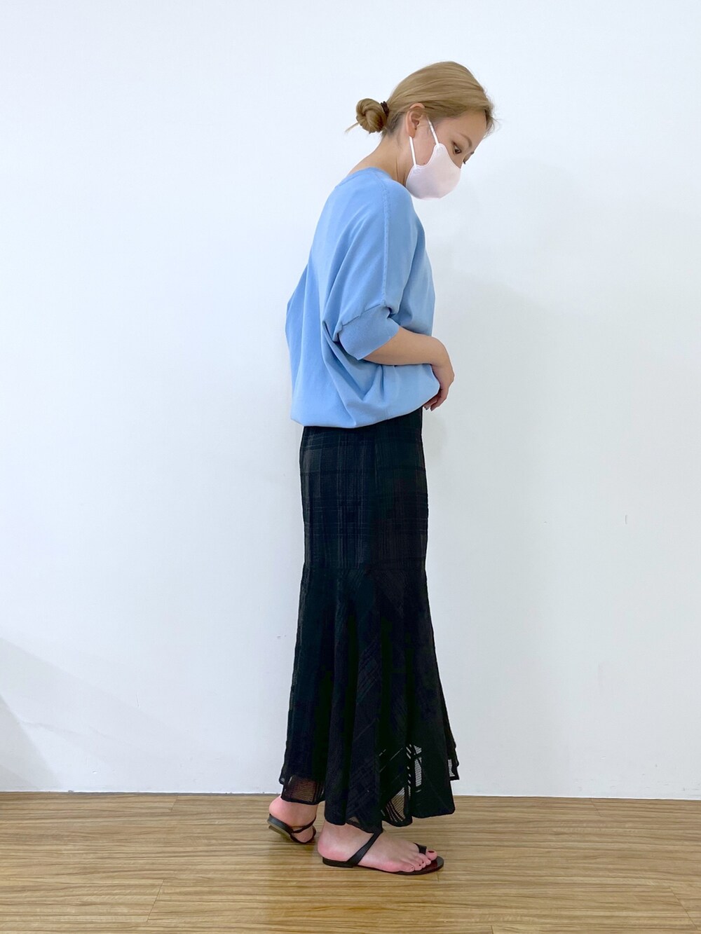 ブルー系のニット/セーター、ブラック系のスカート、ブラック系のその他シューズを着用したレディースの春コーディネートの3枚目の写真