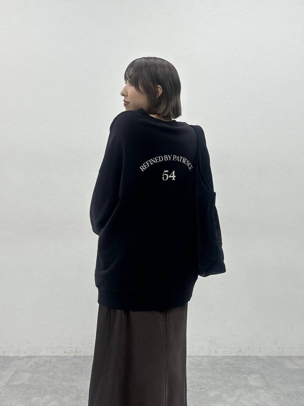 ブラック系のブーツ、ブラック系のトートバッグ、ブラック系のスウェットを着用したレディースの秋コーディネートの5枚目の写真