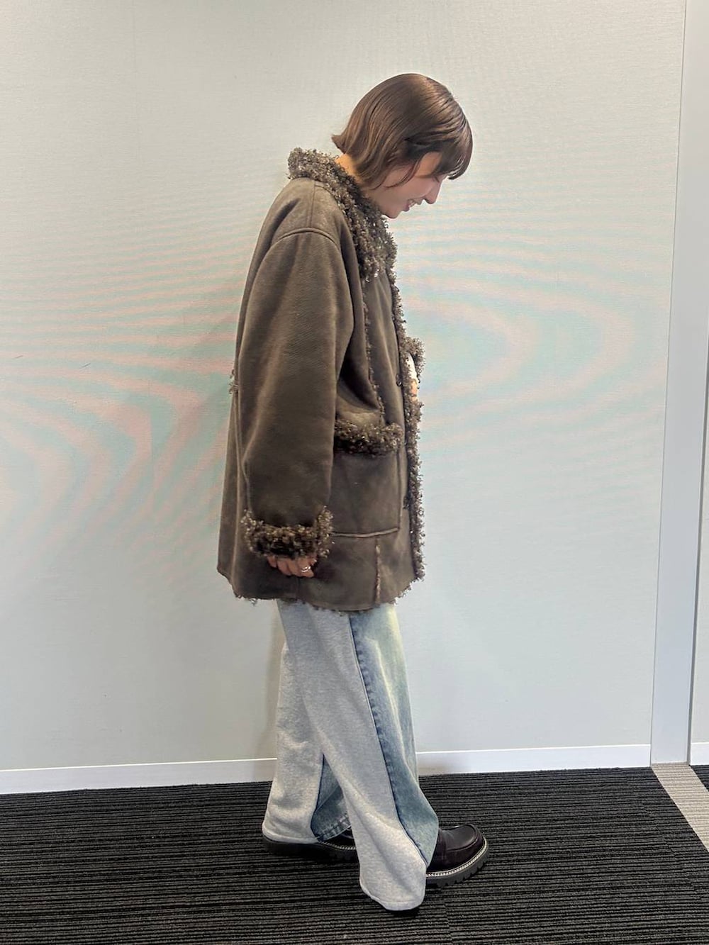 ブルー系のデニムパンツ、ブラウン系のムートンコート、ホワイト系のワンピースを着用したレディースの秋コーディネートの2枚目の写真