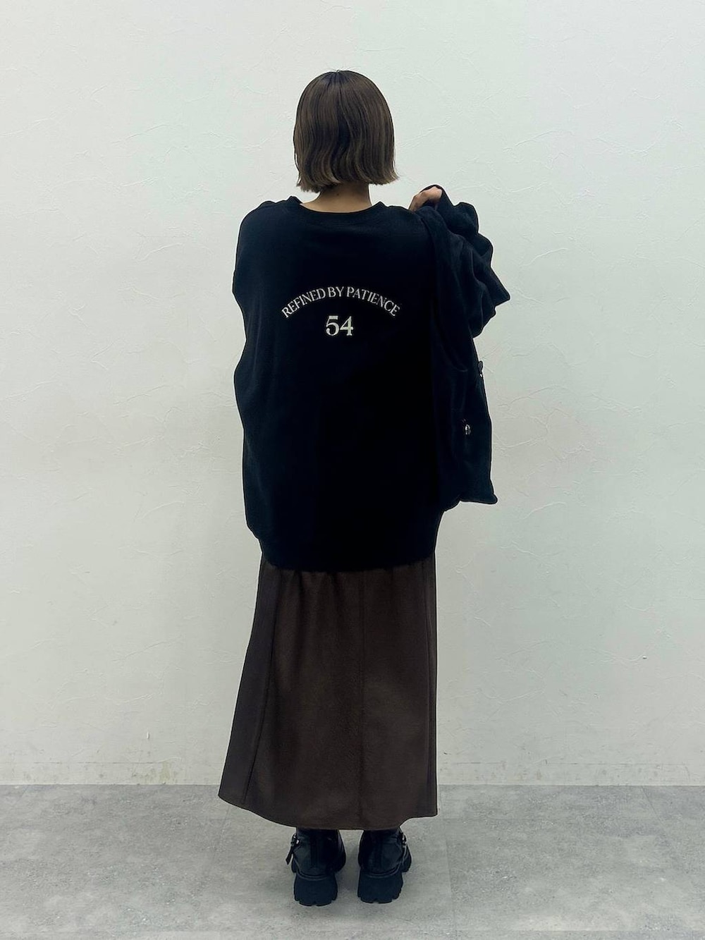 ブラック系のブーツ、ブラック系のトートバッグ、ブラック系のスウェットを着用したレディースの秋コーディネートの3枚目の写真