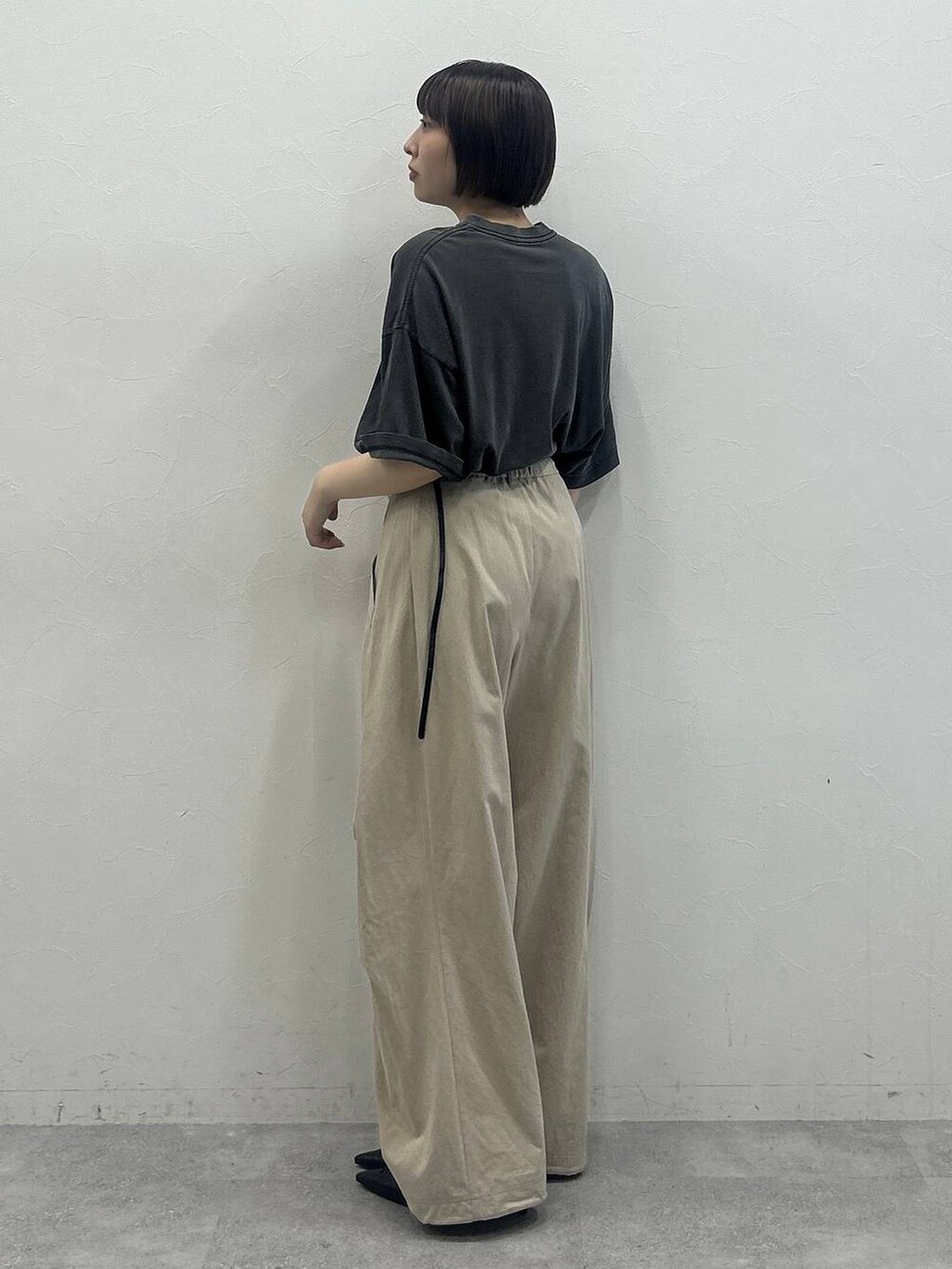 ベージュ系のその他パンツ、ブラック系のTシャツ/カットソー、グリーン系のポーチを着用したレディースの春コーディネートの2枚目の写真