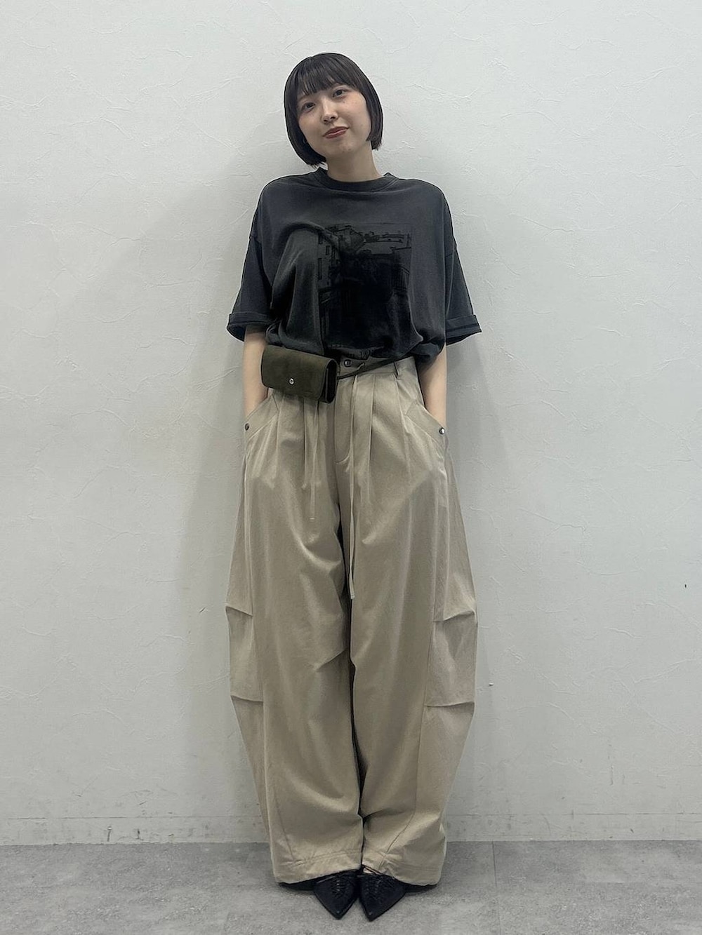 ベージュ系のその他パンツ、ブラック系のTシャツ/カットソー、グリーン系のポーチを着用したレディースの春コーディネートの4枚目の写真