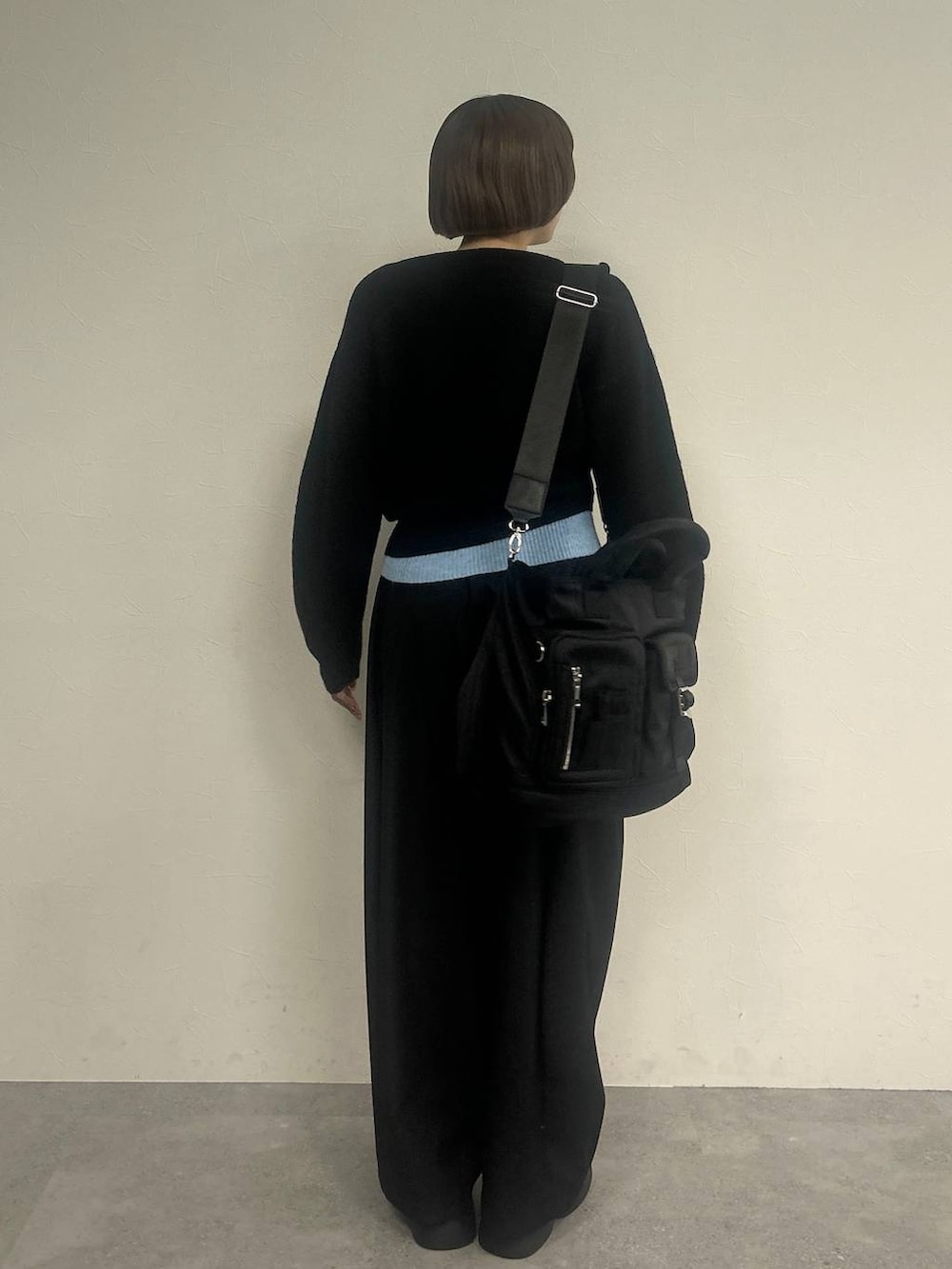 ブラック系のスラックス、ブラック系のトートバッグ、ブラック系のニット/セーターを着用したレディースの秋コーディネートの2枚目の写真