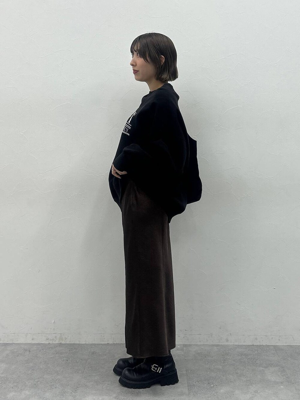 ブラック系のブーツ、ブラック系のトートバッグ、ブラック系のスウェットを着用したレディースの秋コーディネートの2枚目の写真