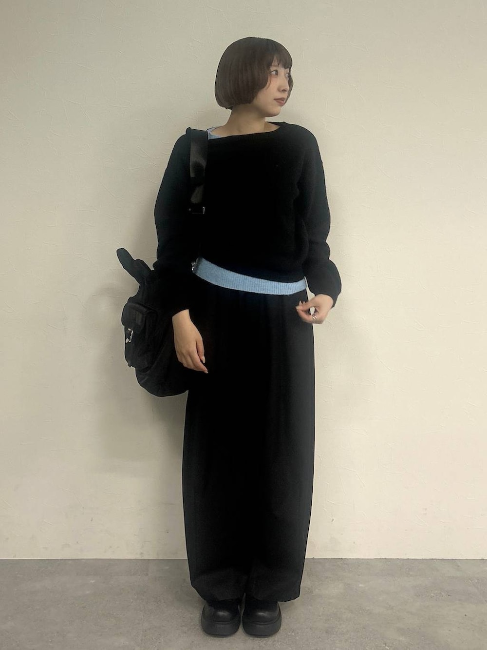 ブラック系のスラックス、ブラック系のトートバッグ、ブラック系のニット/セーターを着用したレディースの秋コーディネートの3枚目の写真