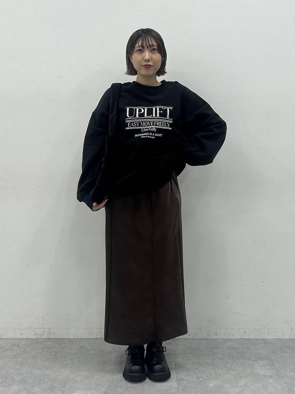 ブラック系のブーツ、ブラック系のトートバッグ、ブラック系のスウェットを着用したレディースの秋コーディネートの4枚目の写真