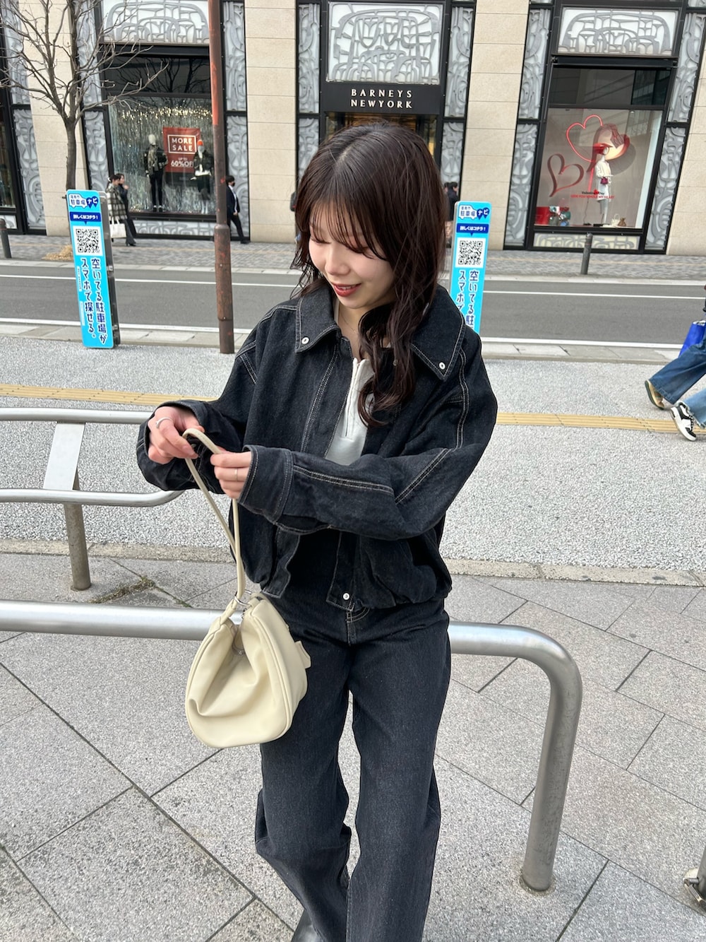 ホワイト系のショルダーバッグ、ブラック系のデニムパンツ、ブラック系のブルゾンを着用したレディースの冬コーディネートの2枚目の写真