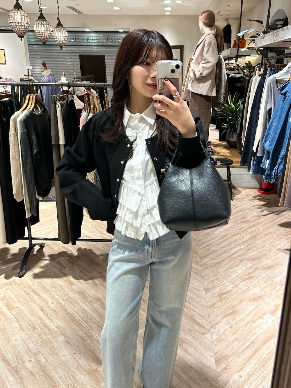 ホワイト系のシャツ/ブラウス、ブラック系のTシャツ/カットソー、ブルー系のデニムパンツを着用したレディースの冬コーディネートの3枚目の写真