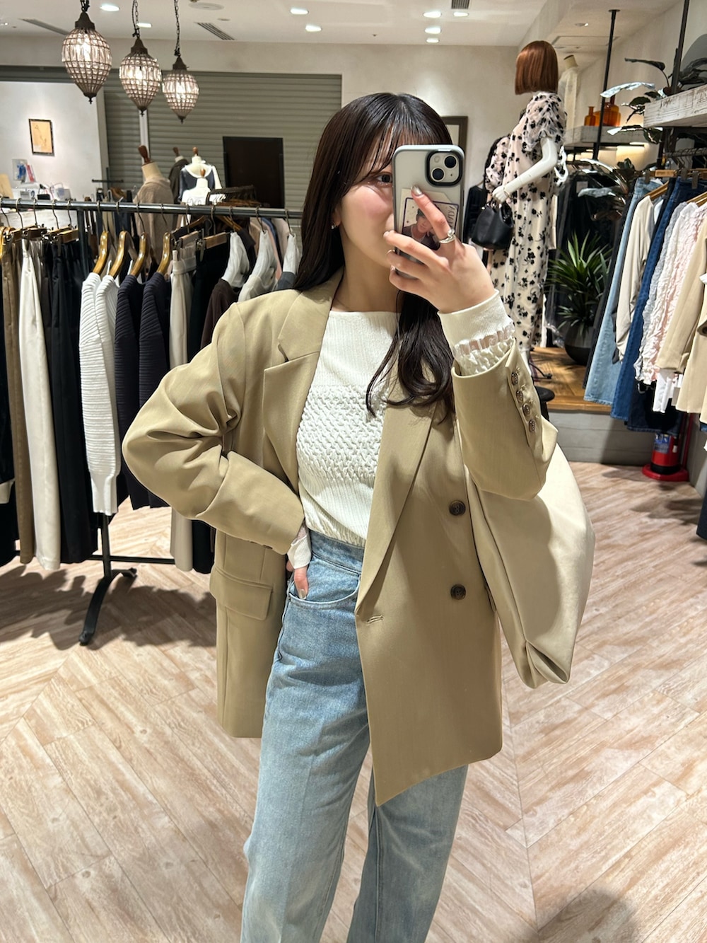 ベージュ系のテーラードジャケット、ブルー系のデニムパンツ、ホワイト系のニット/セーターを着用したレディースの春コーディネートの2枚目の写真