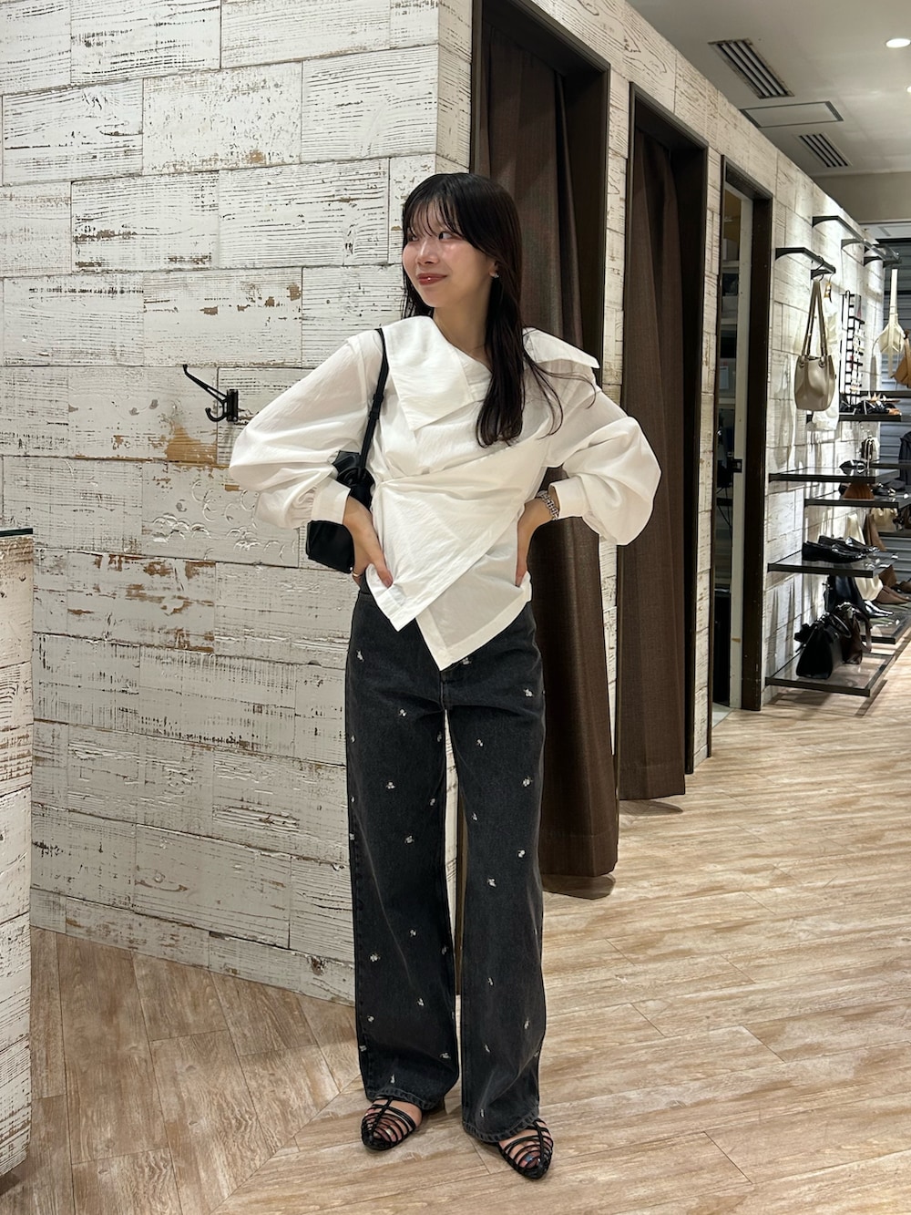 ホワイト系のシャツ/ブラウス、ブラック系のデニムパンツ、ブラック系のショルダーバッグを着用したレディースの秋コーディネートの2枚目の写真