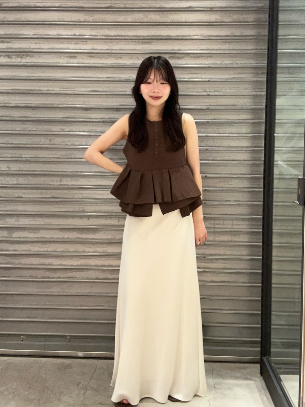 ホワイト系のスカート、ブラウン系のパンプス、ブラウン系のニット/セーターを着用したレディースの夏コーディネートの4枚目の写真