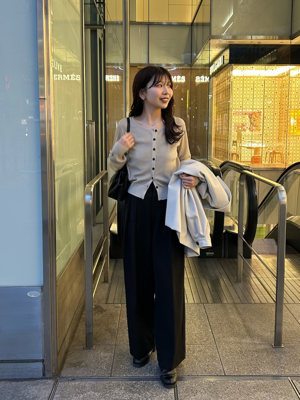 ベージュ系のカーディガン/ボレロ、ブラック系のその他パンツ、ブラック系のショルダーバッグを着用したレディースの春コーディネートの2枚目の写真