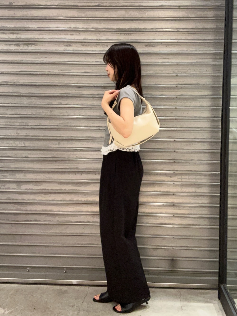 ブラック系のパンプス、ホワイト系のショルダーバッグ、グレー系のTシャツ/カットソーを着用したレディースの夏コーディネートの2枚目の写真