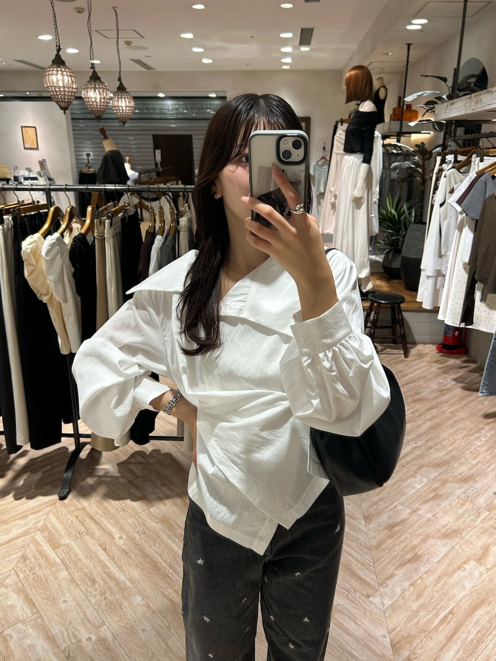 ホワイト系のシャツ/ブラウス、ブラック系のデニムパンツ、ブラック系のショルダーバッグを着用したレディースの秋コーディネートの5枚目の写真