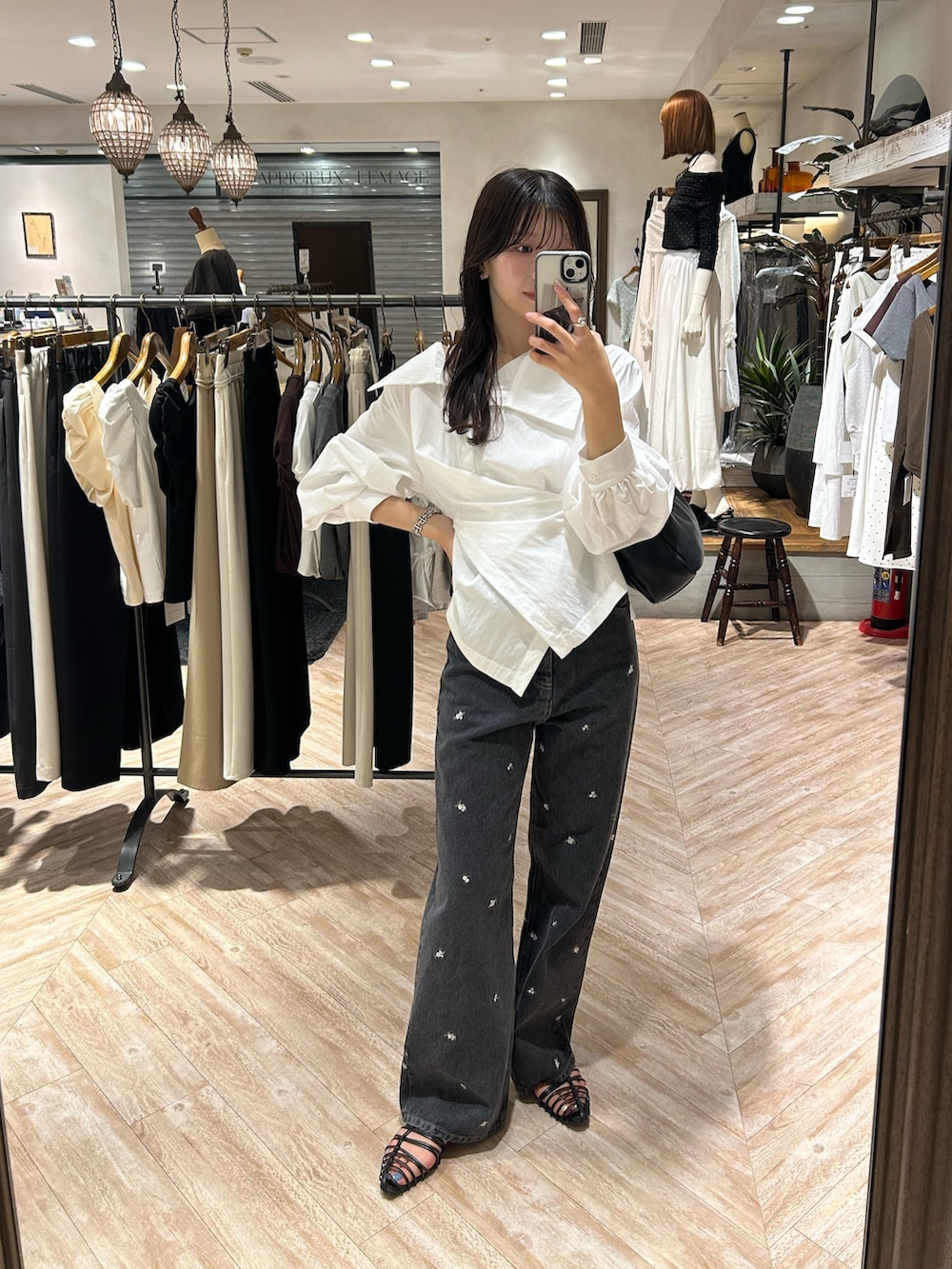 ホワイト系のシャツ/ブラウス、ブラック系のデニムパンツ、ブラック系のショルダーバッグを着用したレディースの秋コーディネートの6枚目の写真