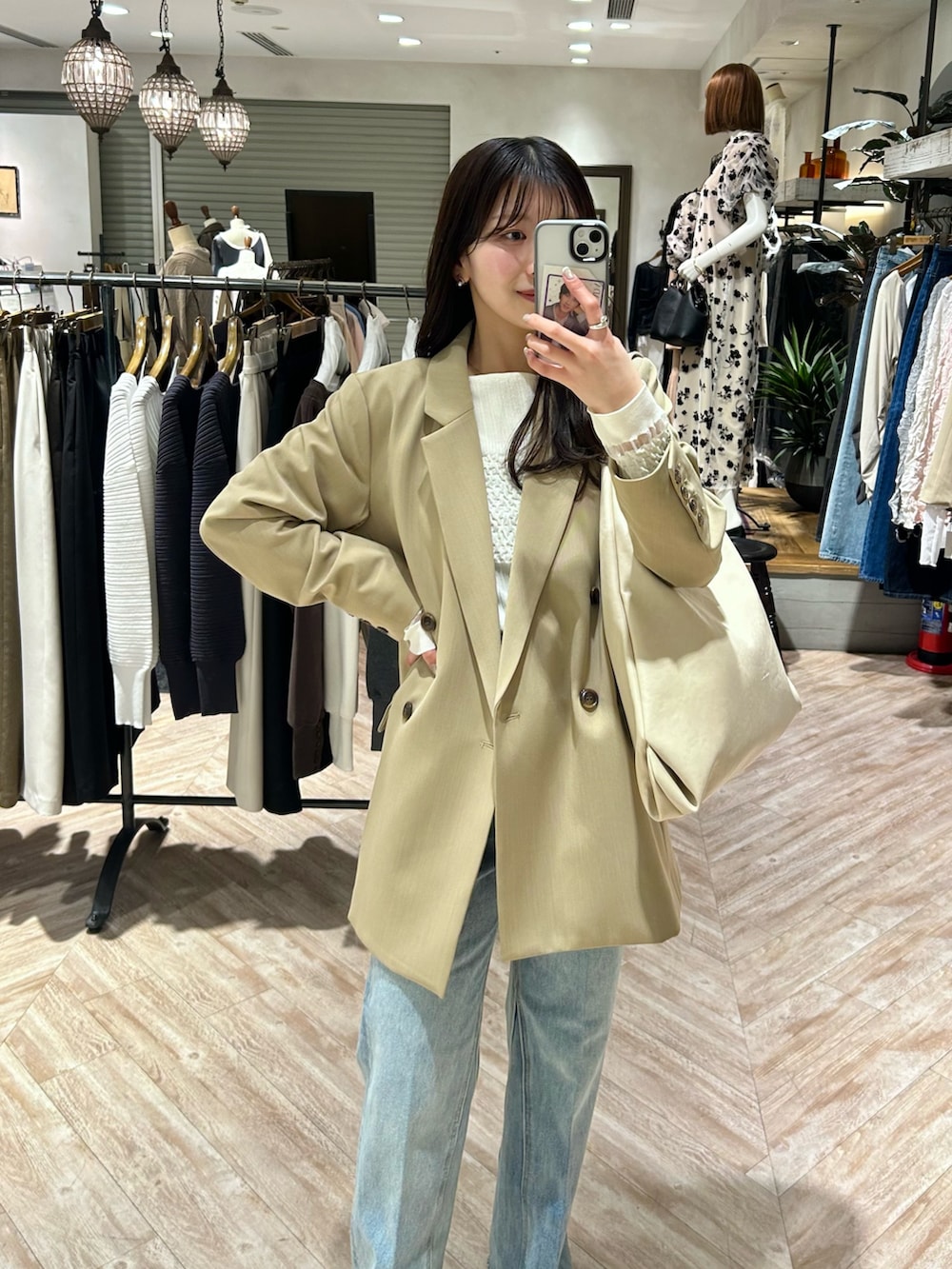 ベージュ系のテーラードジャケット、ブルー系のデニムパンツ、ホワイト系のニット/セーターを着用したレディースの春コーディネートの3枚目の写真