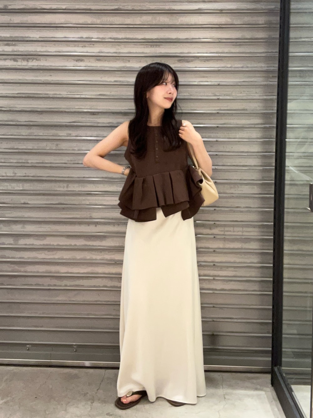 ホワイト系のスカート、ブラウン系のパンプス、ブラウン系のニット/セーターを着用したレディースの夏コーディネートの2枚目の写真