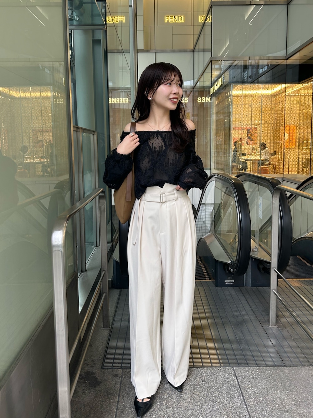 イエロー系のショルダーバッグ、ブラック系のパンプス、ブラック系のシャツ/ブラウスを着用したレディースの冬コーディネートの2枚目の写真