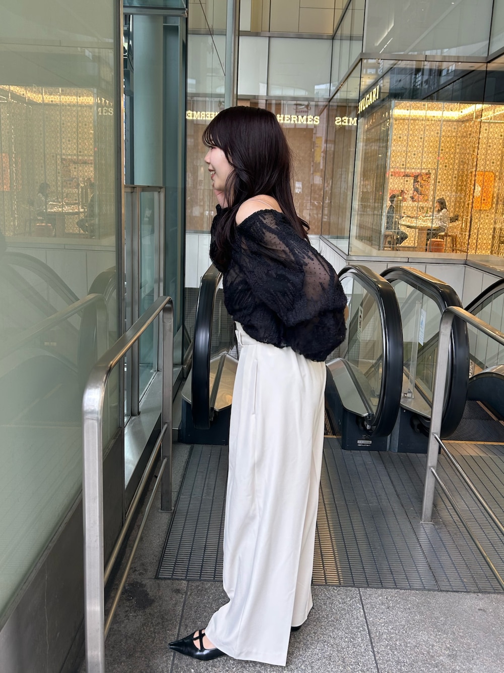 イエロー系のショルダーバッグ、ブラック系のパンプス、ブラック系のシャツ/ブラウスを着用したレディースの冬コーディネートの3枚目の写真