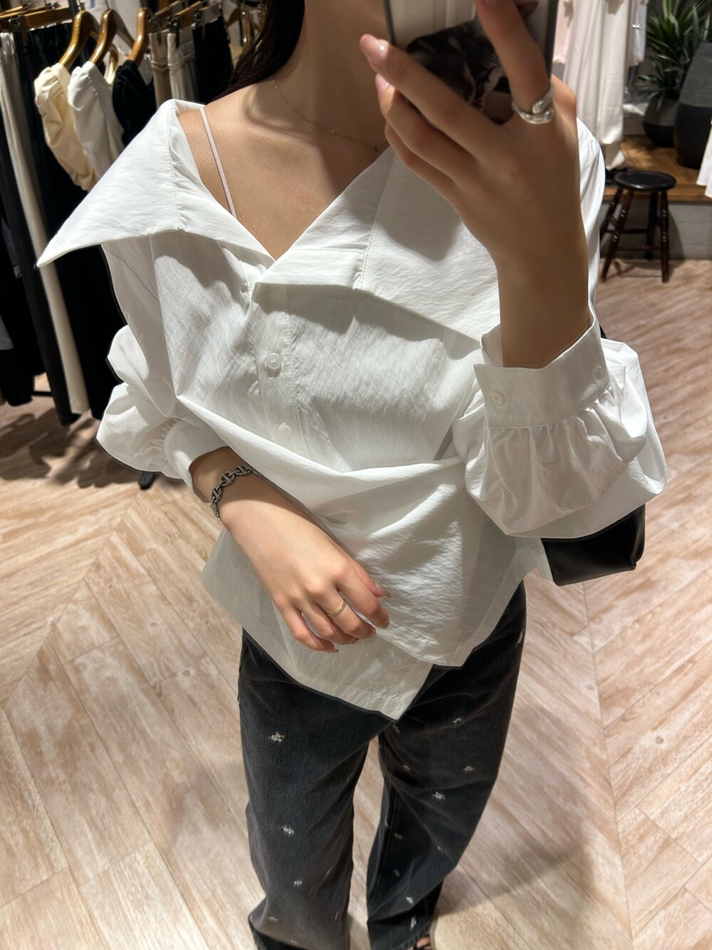 ホワイト系のシャツ/ブラウス、ブラック系のデニムパンツ、ブラック系のショルダーバッグを着用したレディースの秋コーディネートの4枚目の写真