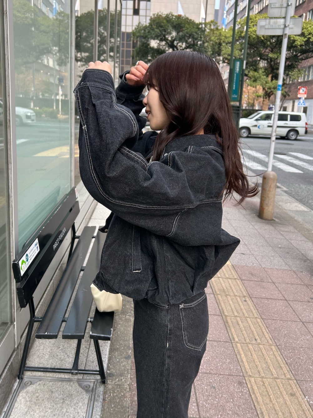 ホワイト系のショルダーバッグ、ブラック系のデニムパンツ、ブラック系のブルゾンを着用したレディースの冬コーディネートの5枚目の写真