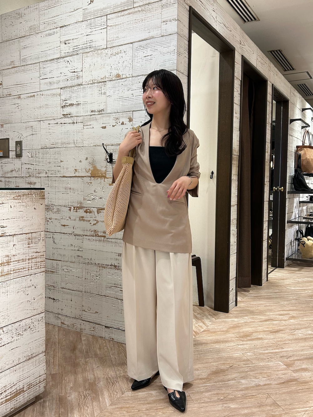 ベージュ系のその他アウター、ホワイト系のその他パンツ、ブラック系のパンプスを着用したレディースの春コーディネートの2枚目の写真