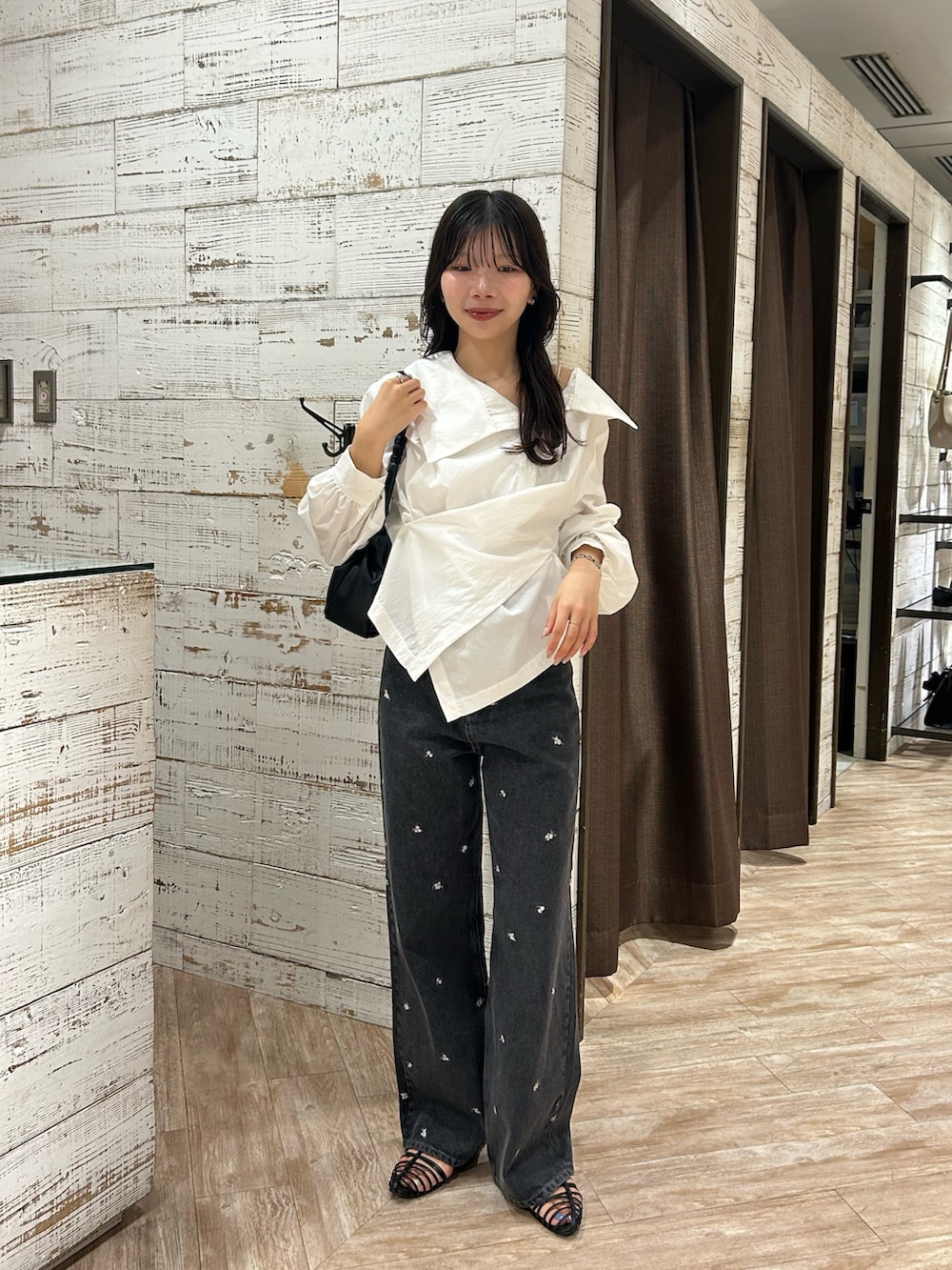 ホワイト系のシャツ/ブラウス、ブラック系のデニムパンツ、ブラック系のショルダーバッグを着用したレディースの秋コーディネートの3枚目の写真