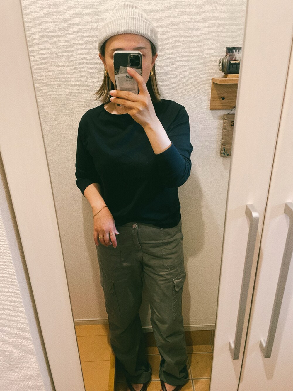 グリーン系のカーゴパンツ、ブラック系のTシャツ/カットソー、ゴールド系のピアス（両耳用）を着用したレディースの秋コーディネートの2枚目の写真