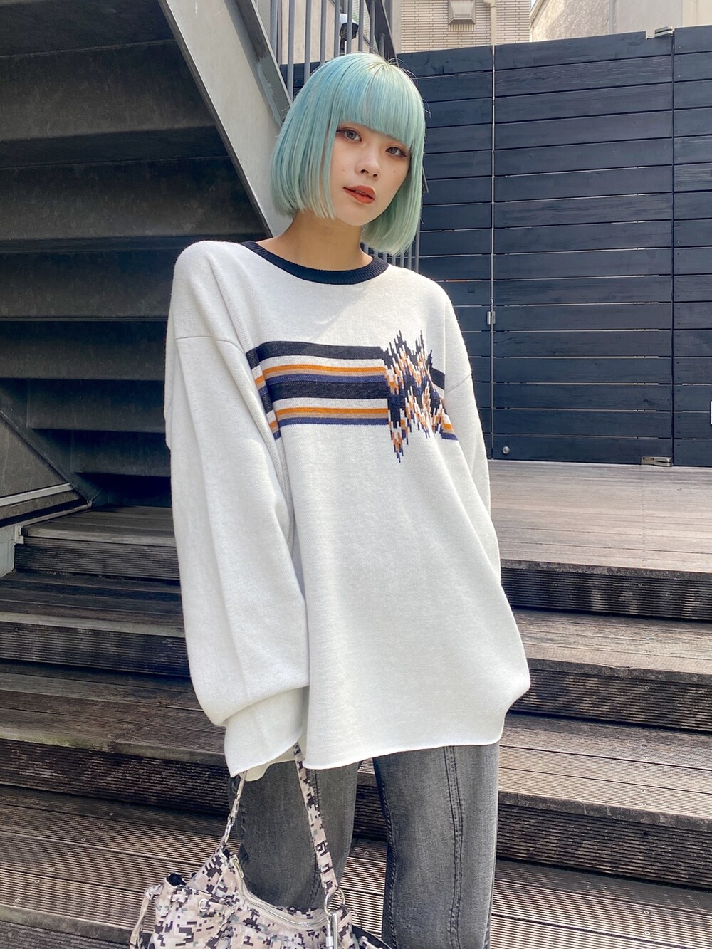 ホワイト系のニット/セーター、ブラック系のデニムパンツを着用したレディースの秋コーディネートの2枚目の写真