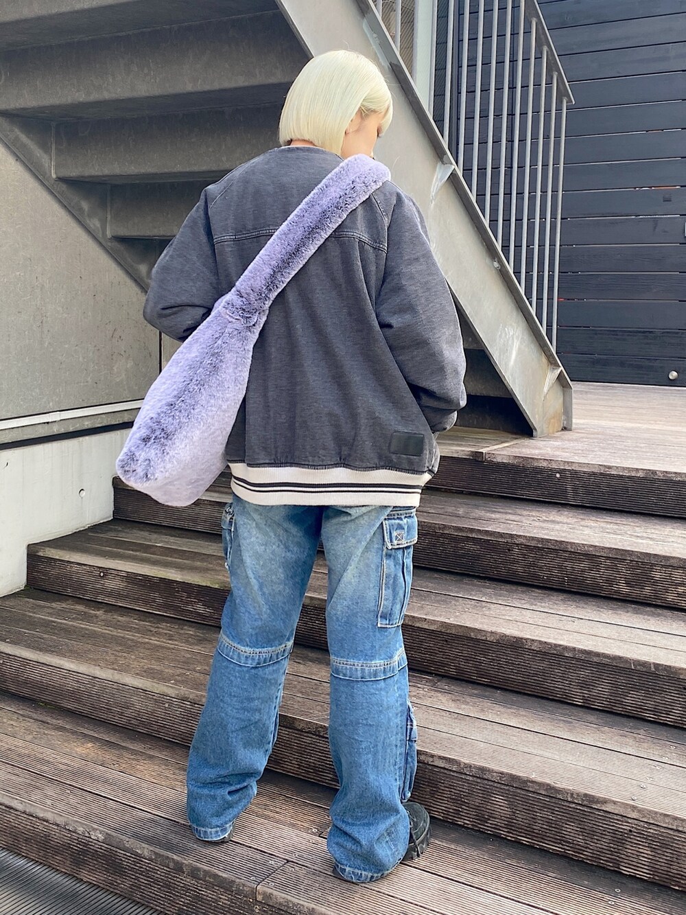 ブラック系のデニムジャケット、ブルー系のデニムパンツを着用したレディースの秋コーディネートの2枚目の写真