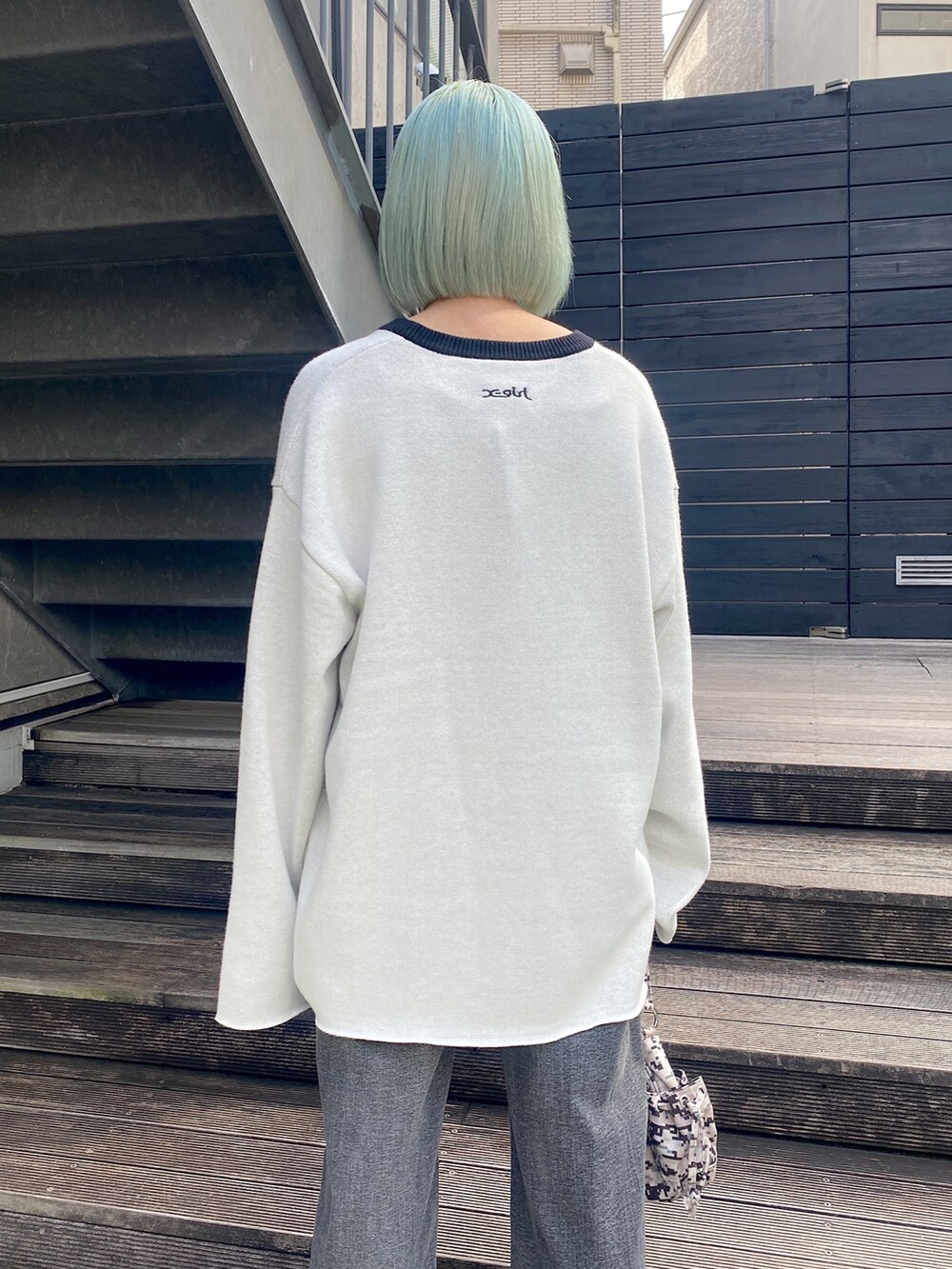 ホワイト系のニット/セーター、ブラック系のデニムパンツを着用したレディースの秋コーディネートの3枚目の写真