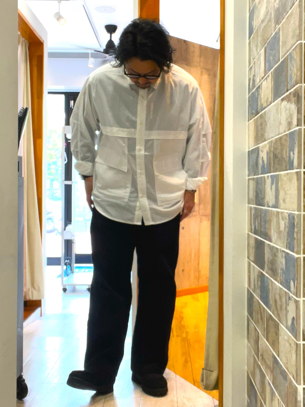 ブラック系のその他パンツ、ブラック系のモカシン/デッキシューズ、ホワイト系のシャツ/ブラウスを着用したメンズの春コーディネートの2枚目の写真