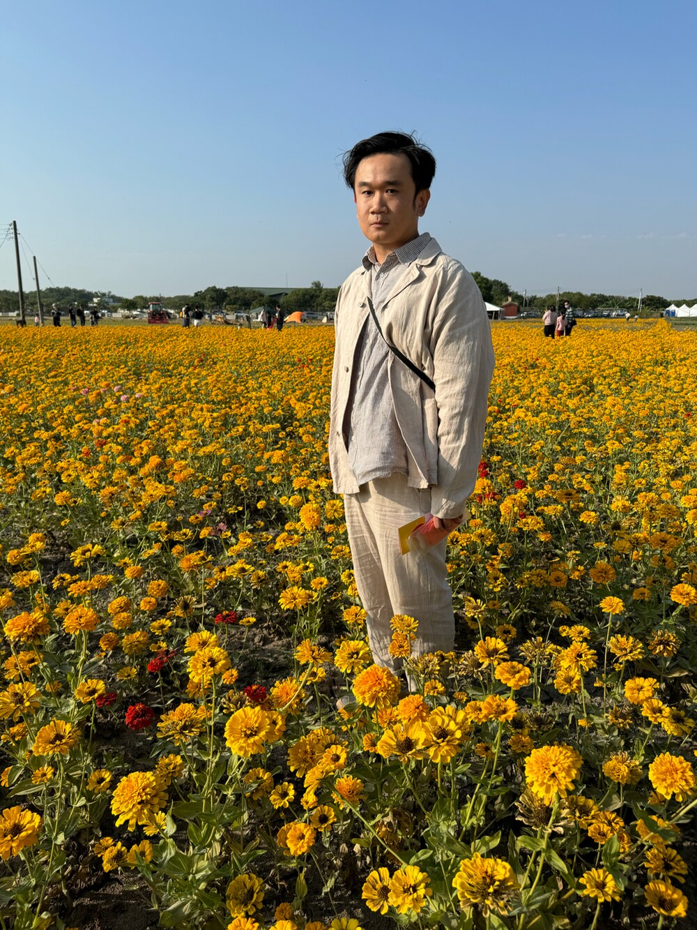 ベージュ系のテーラードジャケット、ベージュ系のチノパンツ、ベージュ系のスニーカーを着用したメンズの冬コーディネートの3枚目の写真