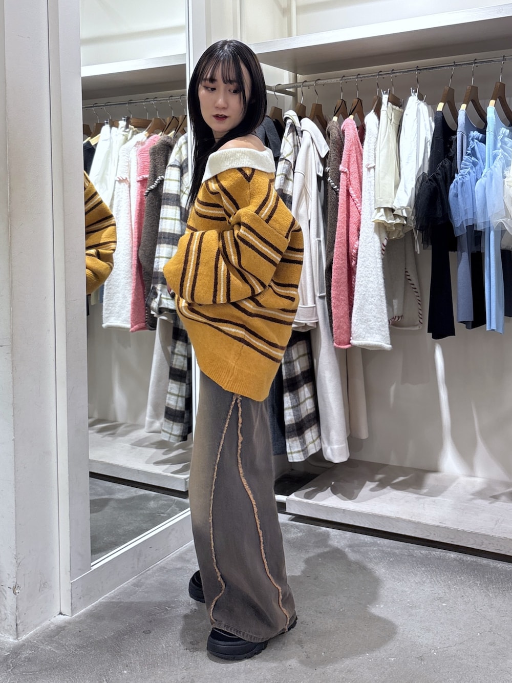 イエロー系のニット/セーター、ブラウン系のデニムパンツを着用したレディースの冬コーディネートの3枚目の写真