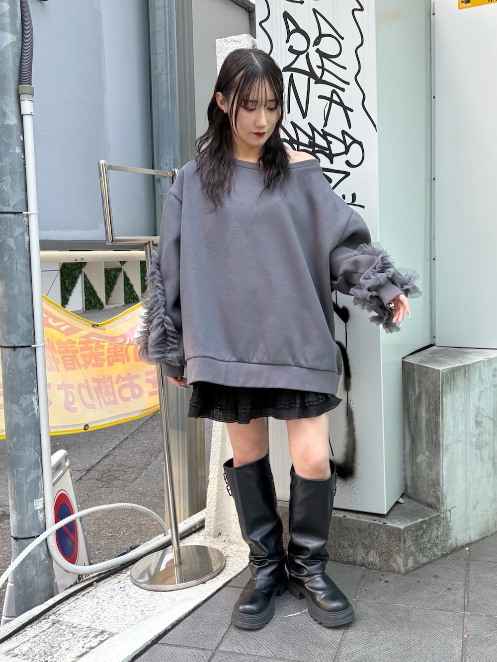 グレー系のTシャツ/カットソー、ブラック系のスカート、ブラック系のブーツを着用したレディースの冬コーディネートの4枚目の写真