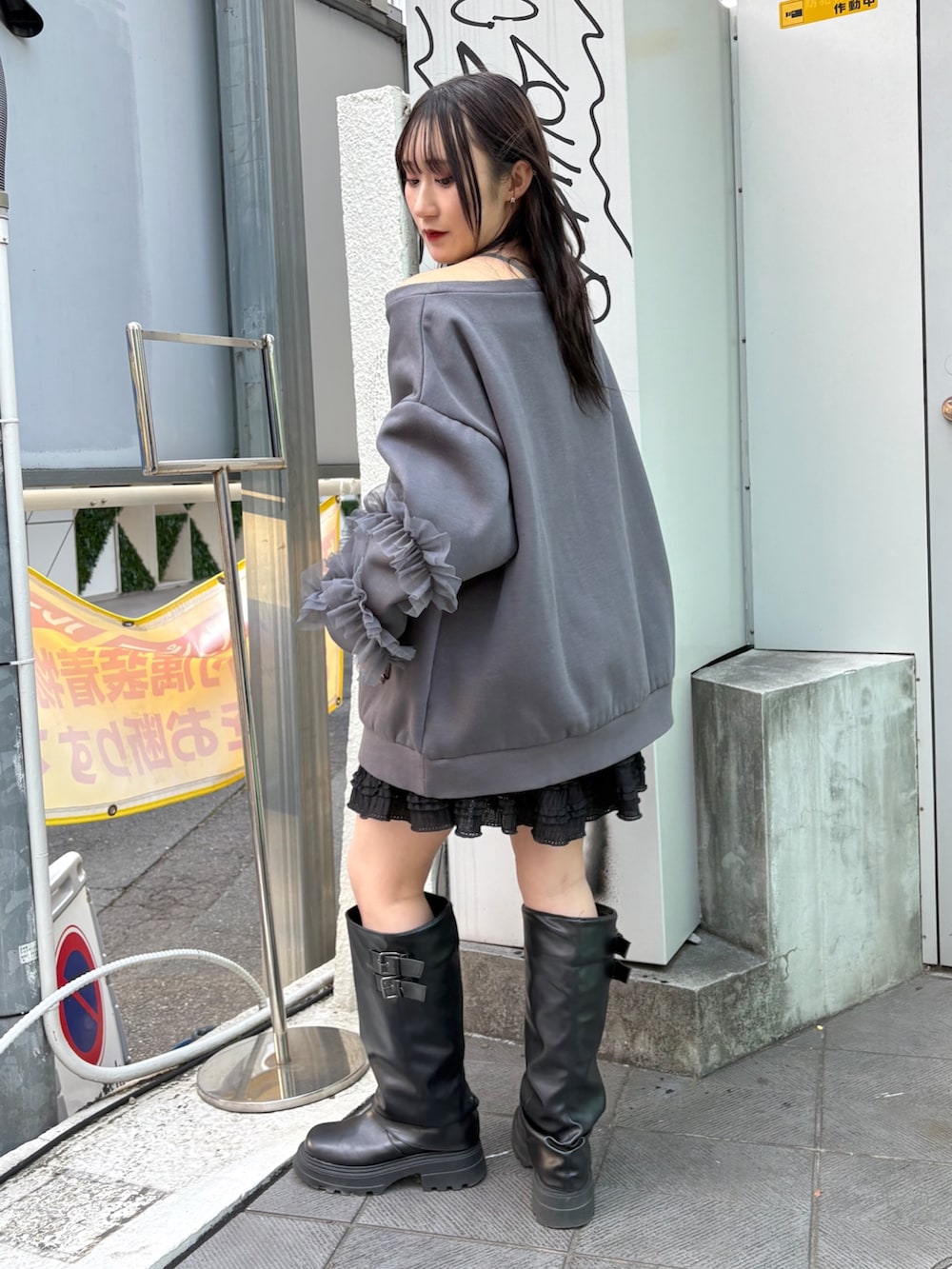 グレー系のTシャツ/カットソー、ブラック系のスカート、ブラック系のブーツを着用したレディースの冬コーディネートの3枚目の写真