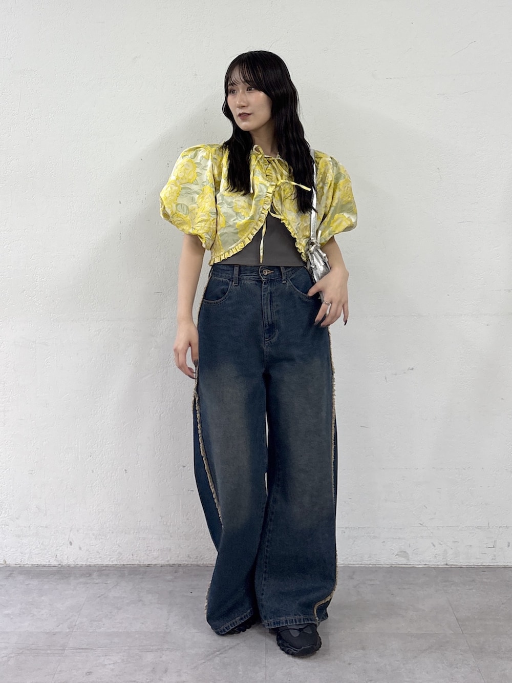 イエロー系のシャツ/ブラウス、ブルー系のデニムパンツ、シルバー系のトートバッグを着用したレディースの夏コーディネートの2枚目の写真